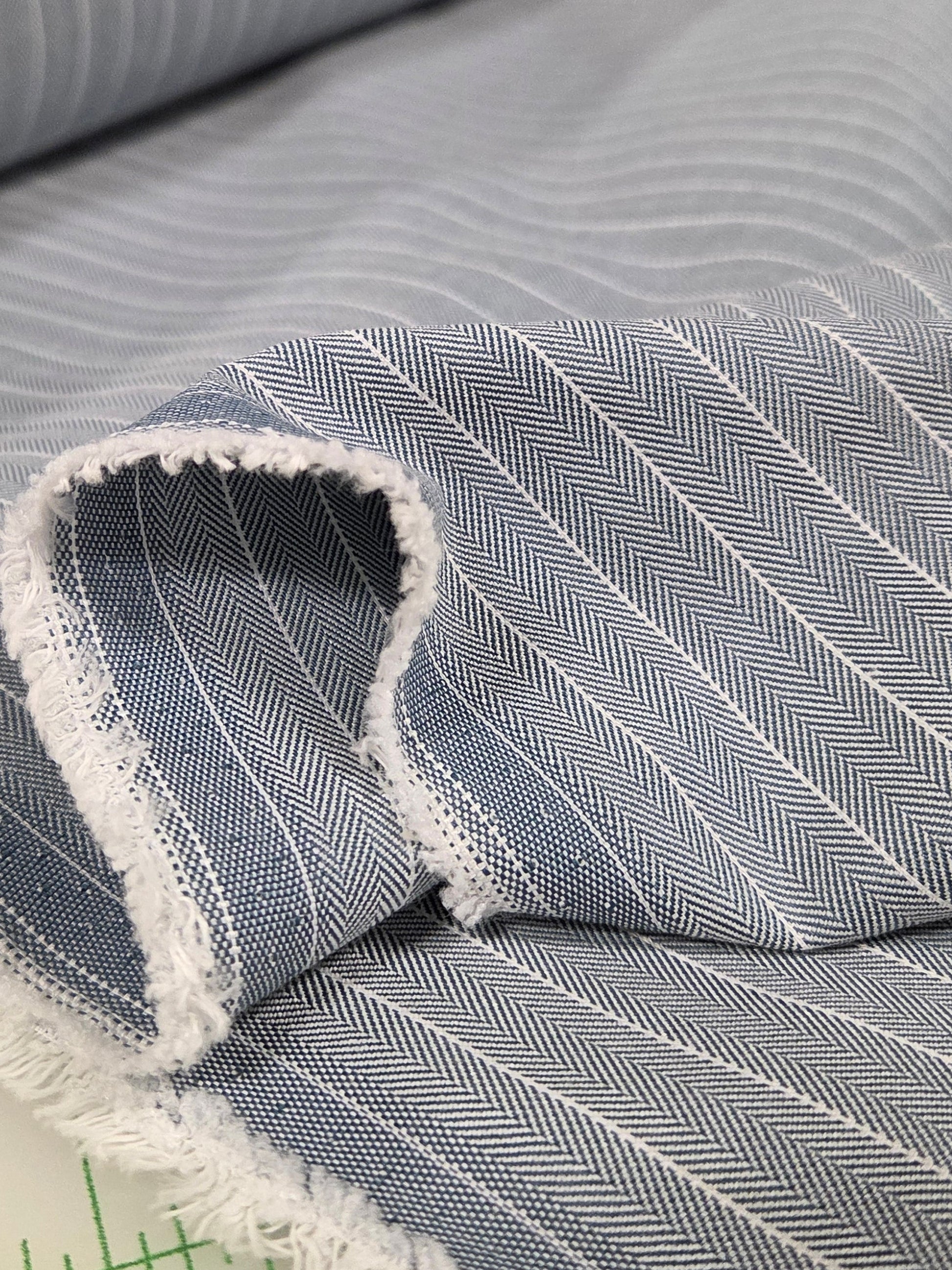 Close-up of gray striped fabric with a ruler in the background