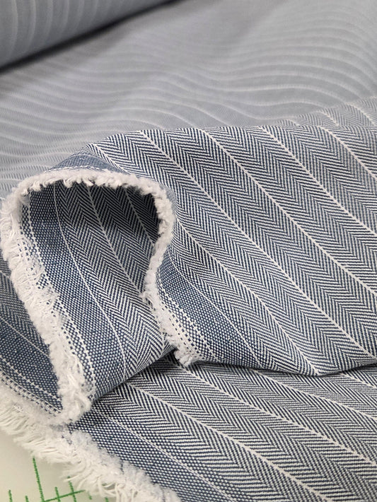 Close-up of gray striped fabric with a ruler in the background