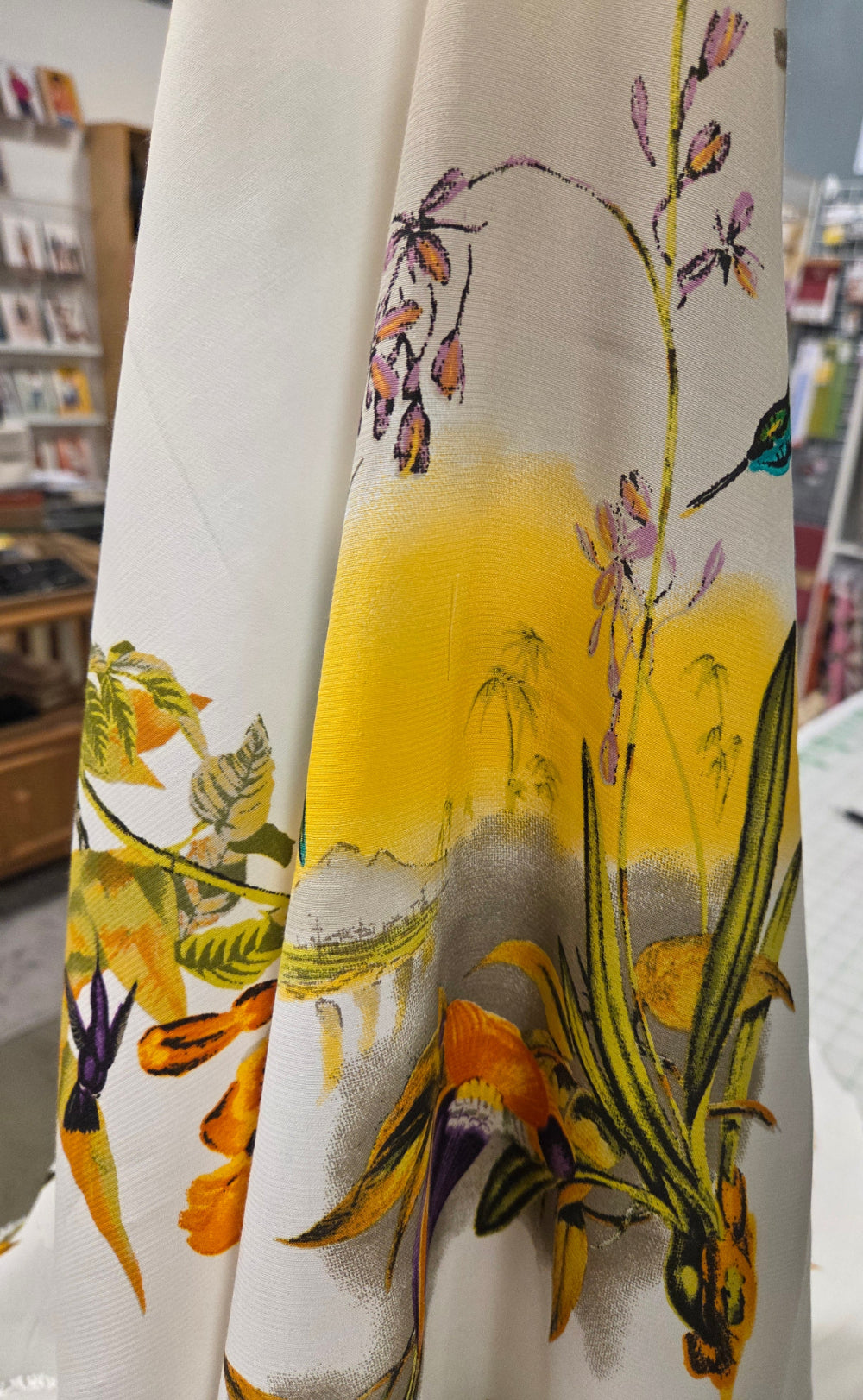 Floral fabric with yellow flowers and green leaves on a white background