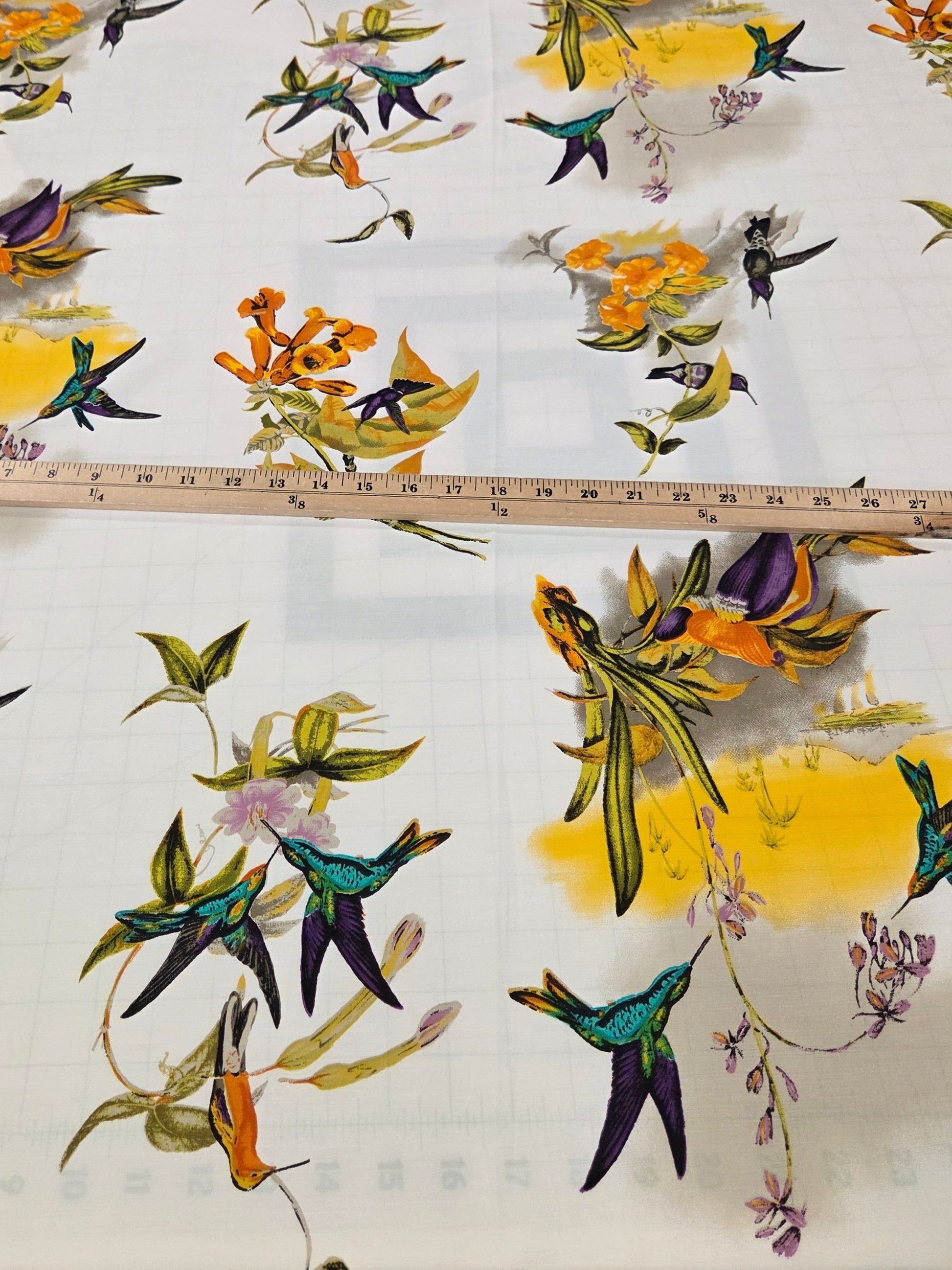 Fabric with colorful bird and flower pattern on a cutting mat