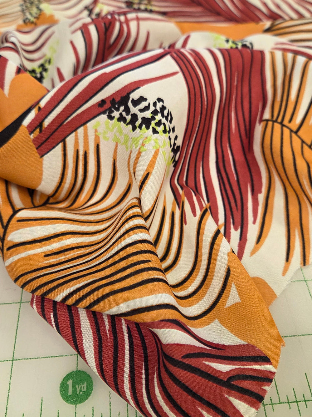 Fabric with abstract pattern on a cutting mat. fashion fabrics by the yard