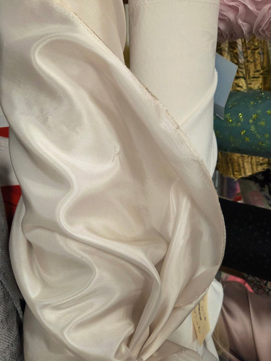 Close-up of a beige fabric with a bow, surrounded by colorful textured items.