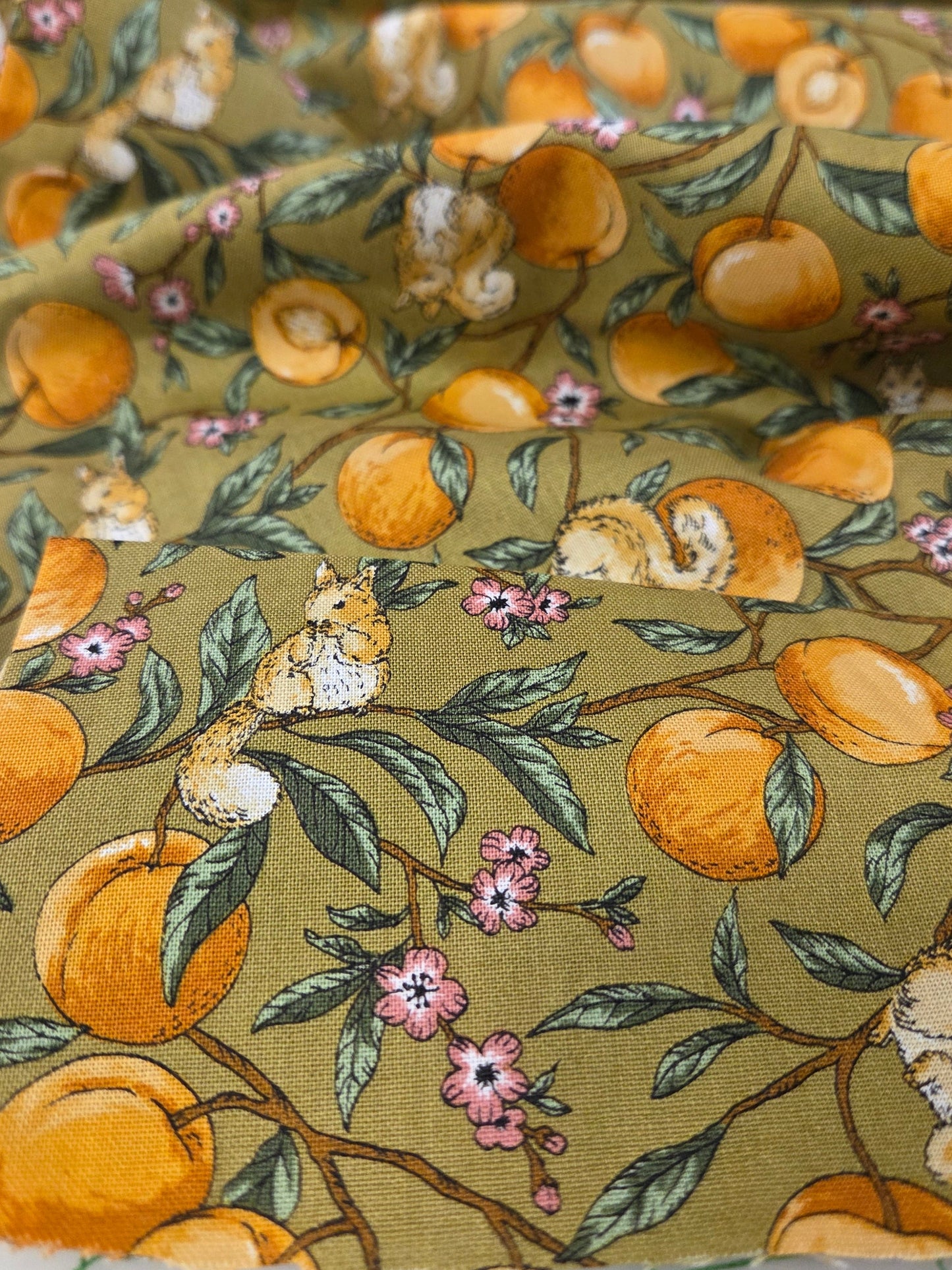 Fabric with a floral and fruit pattern on a green background