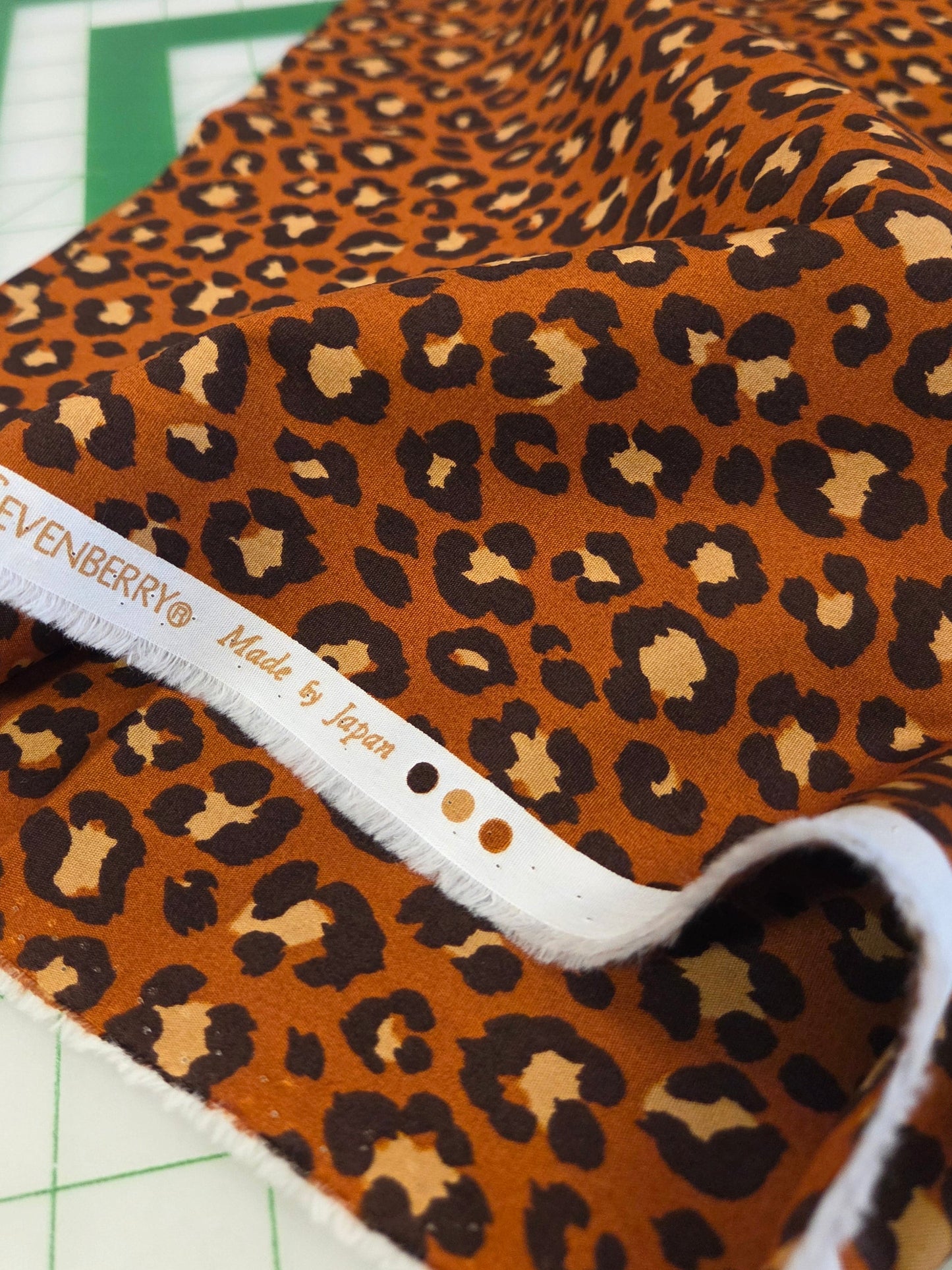 Leopard print fabric with Sevenberry label on a cutting mat
