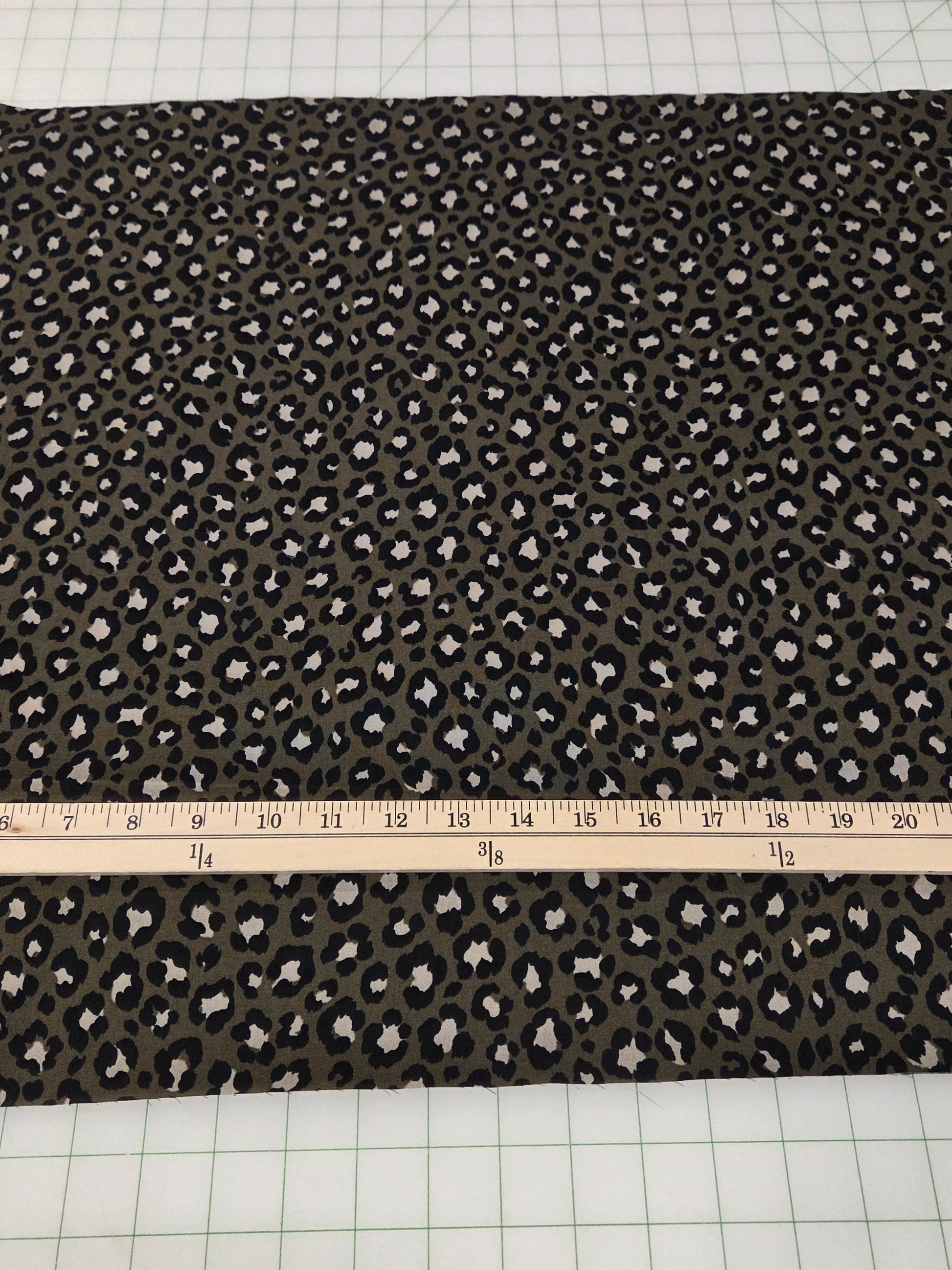 Fabric with a pattern on a cutting mat with a ruler and scissors.