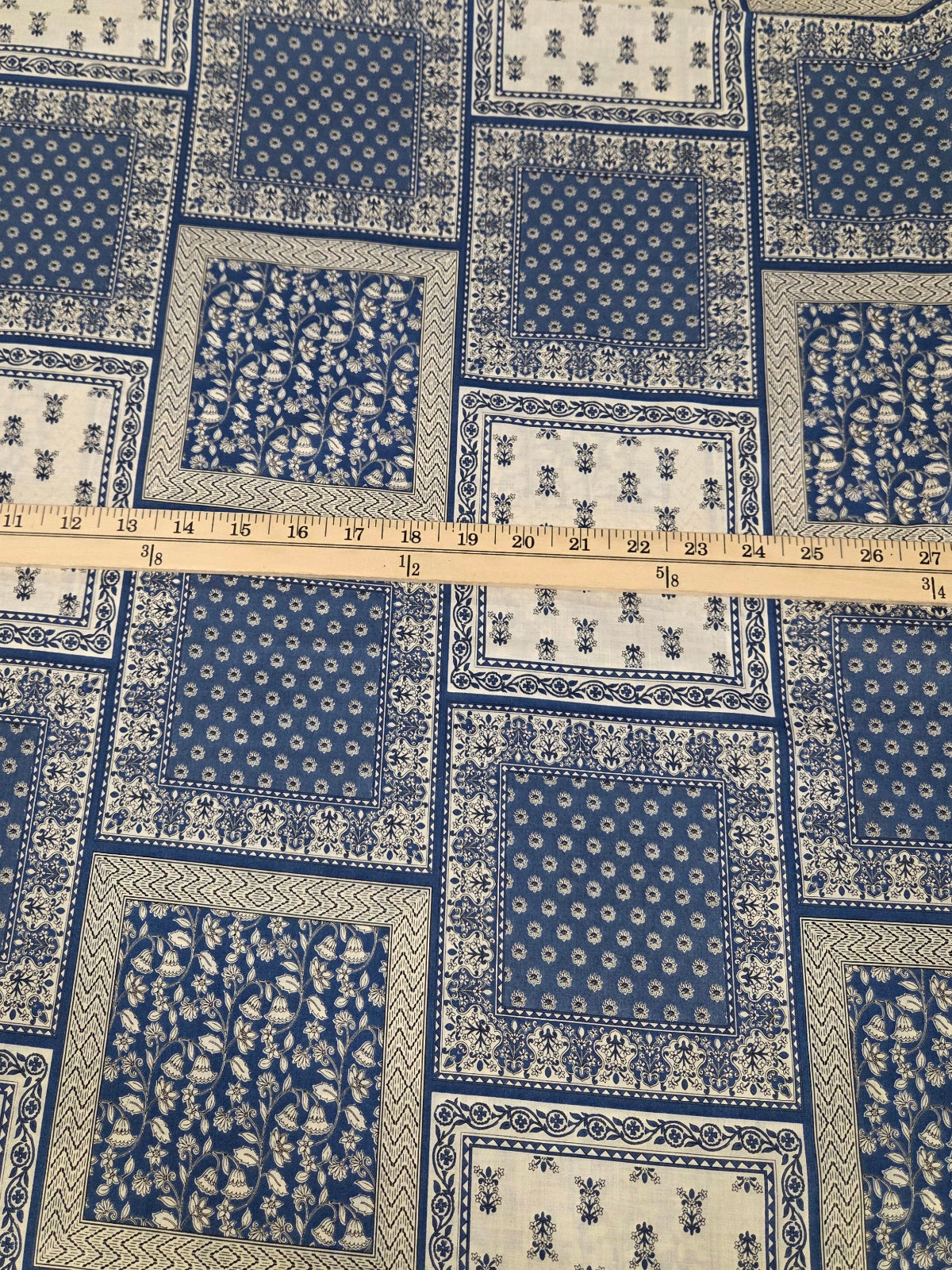 Blue and white patterned fabric with a ruler for scale on a grid background