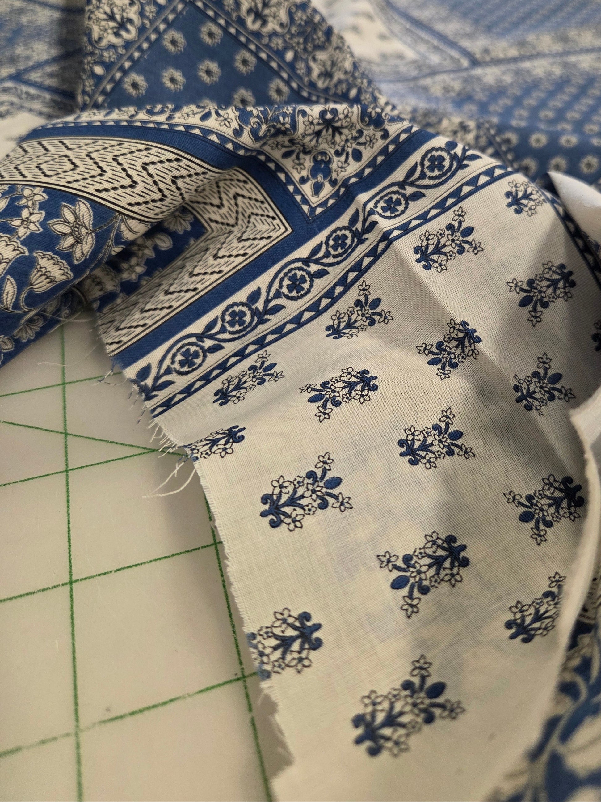 Close-up of blue and white patterned fabric on a cutting mat