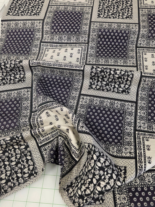Patchwork fabric with black and white patterns on a cutting mat. hokkoh japan import bandana