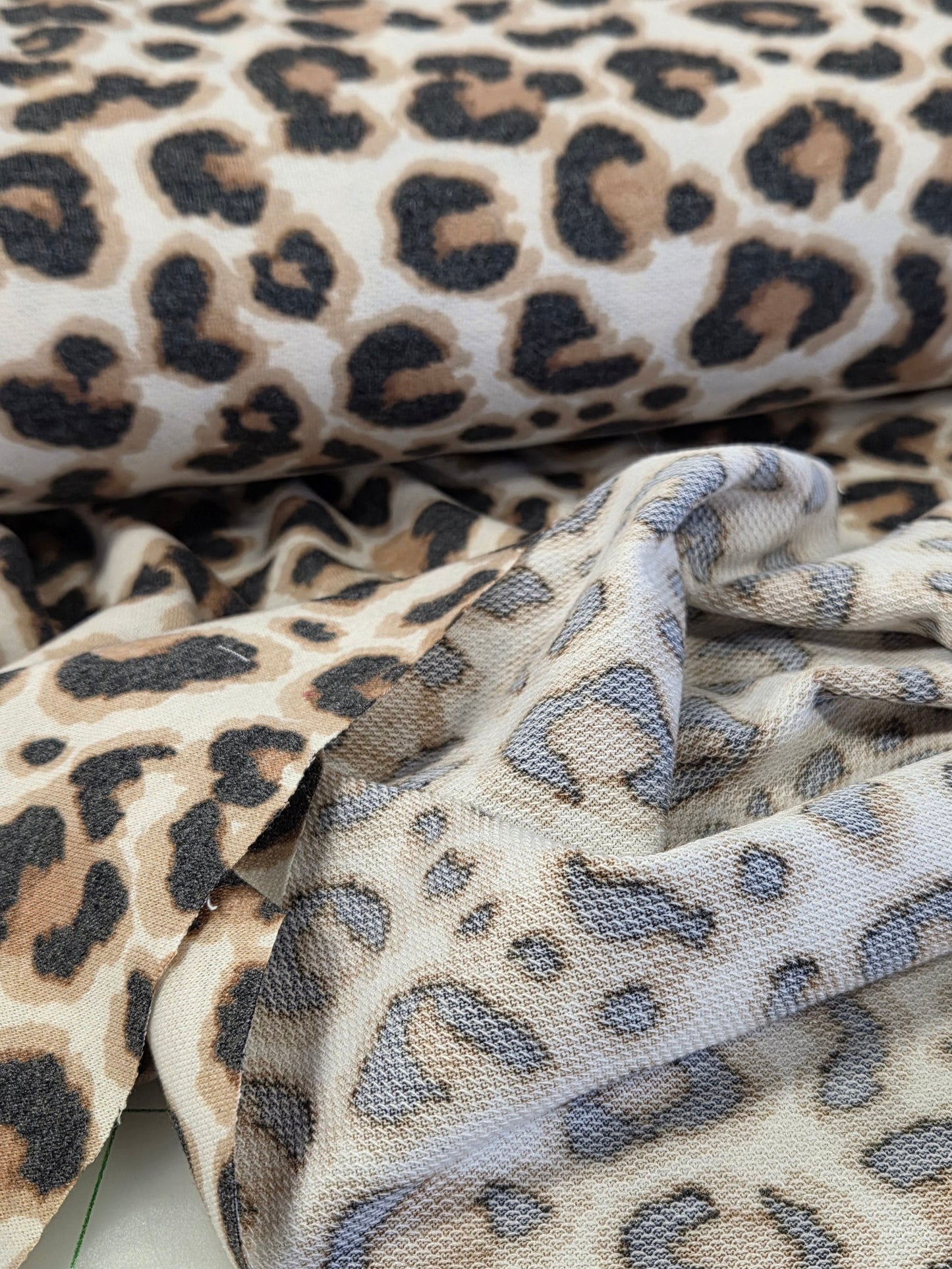Leopard print fabric with a textured pattern on a tiled background