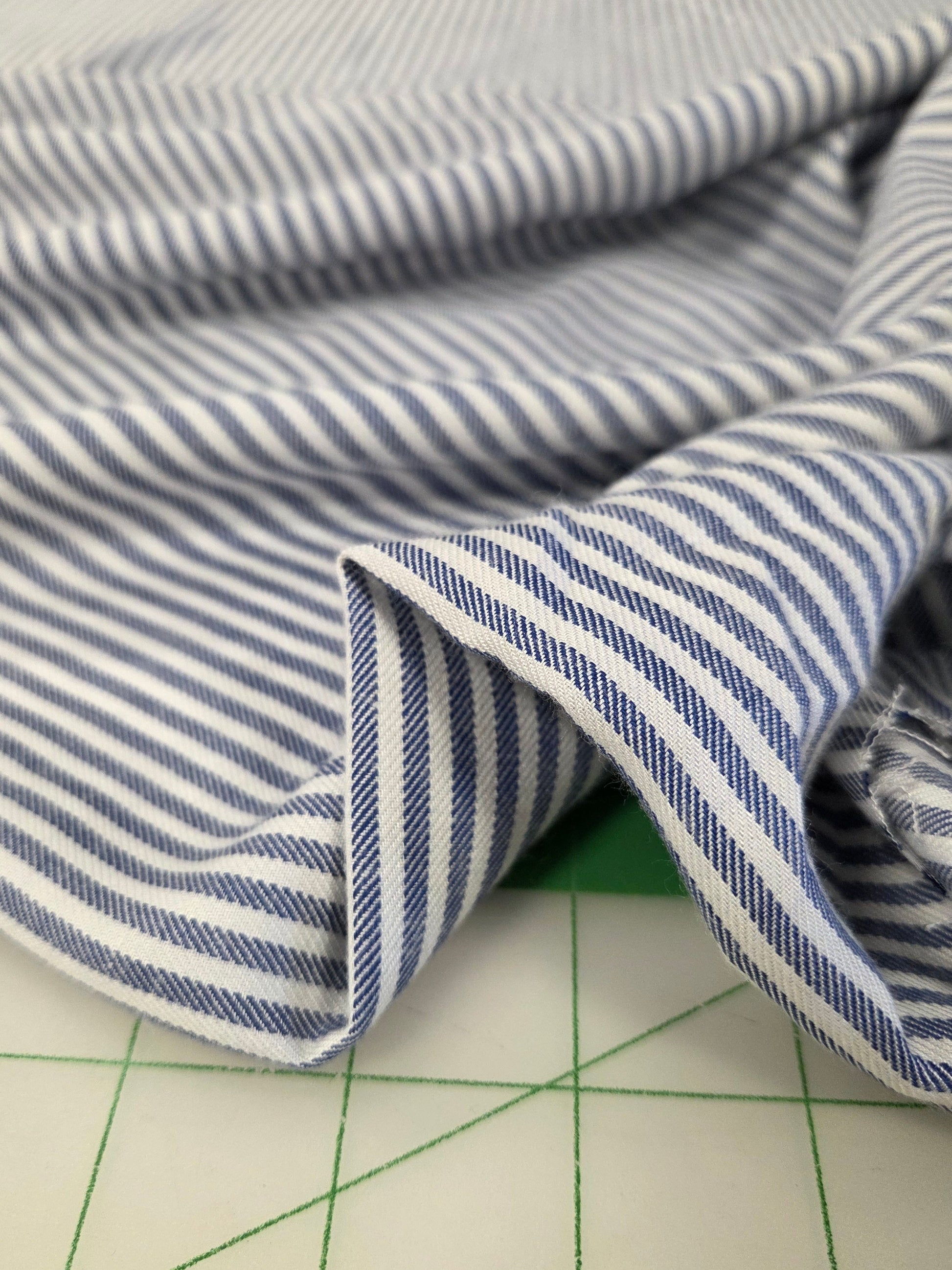 Blue and white striped fabric on a grid background