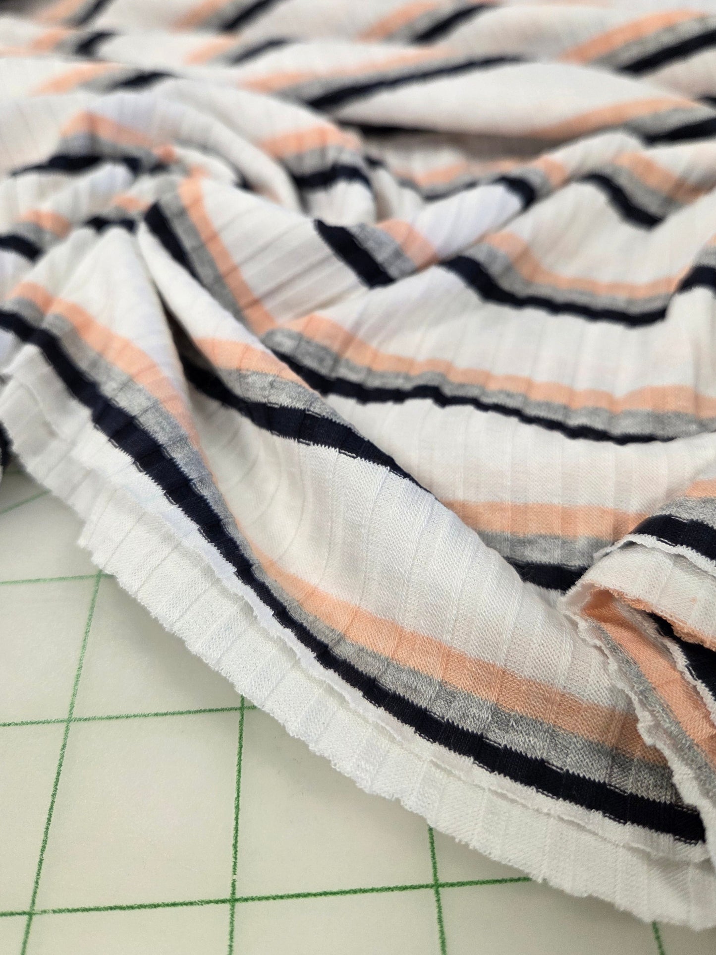 Striped fabric on a cutting mat with grid lines