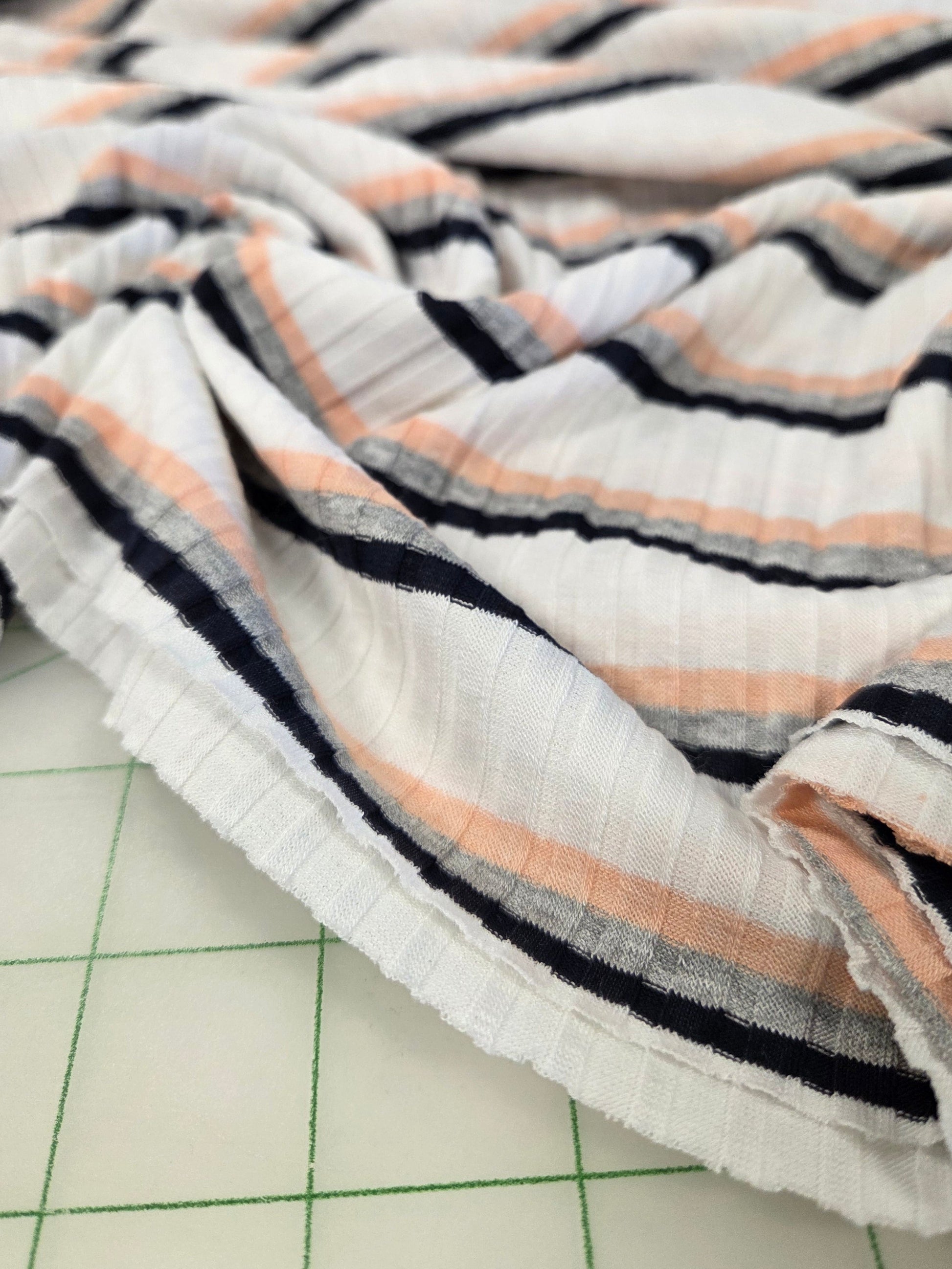 Striped fabric on a cutting mat with grid lines