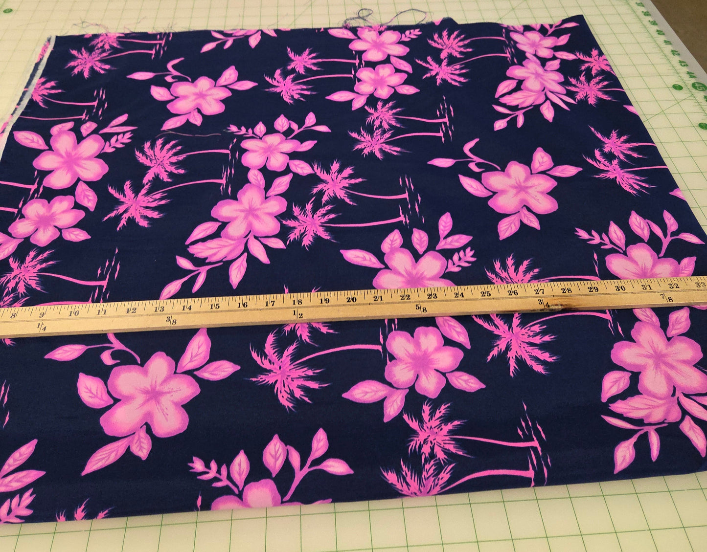 Fabric with pink floral pattern on a cutting mat with a ruler