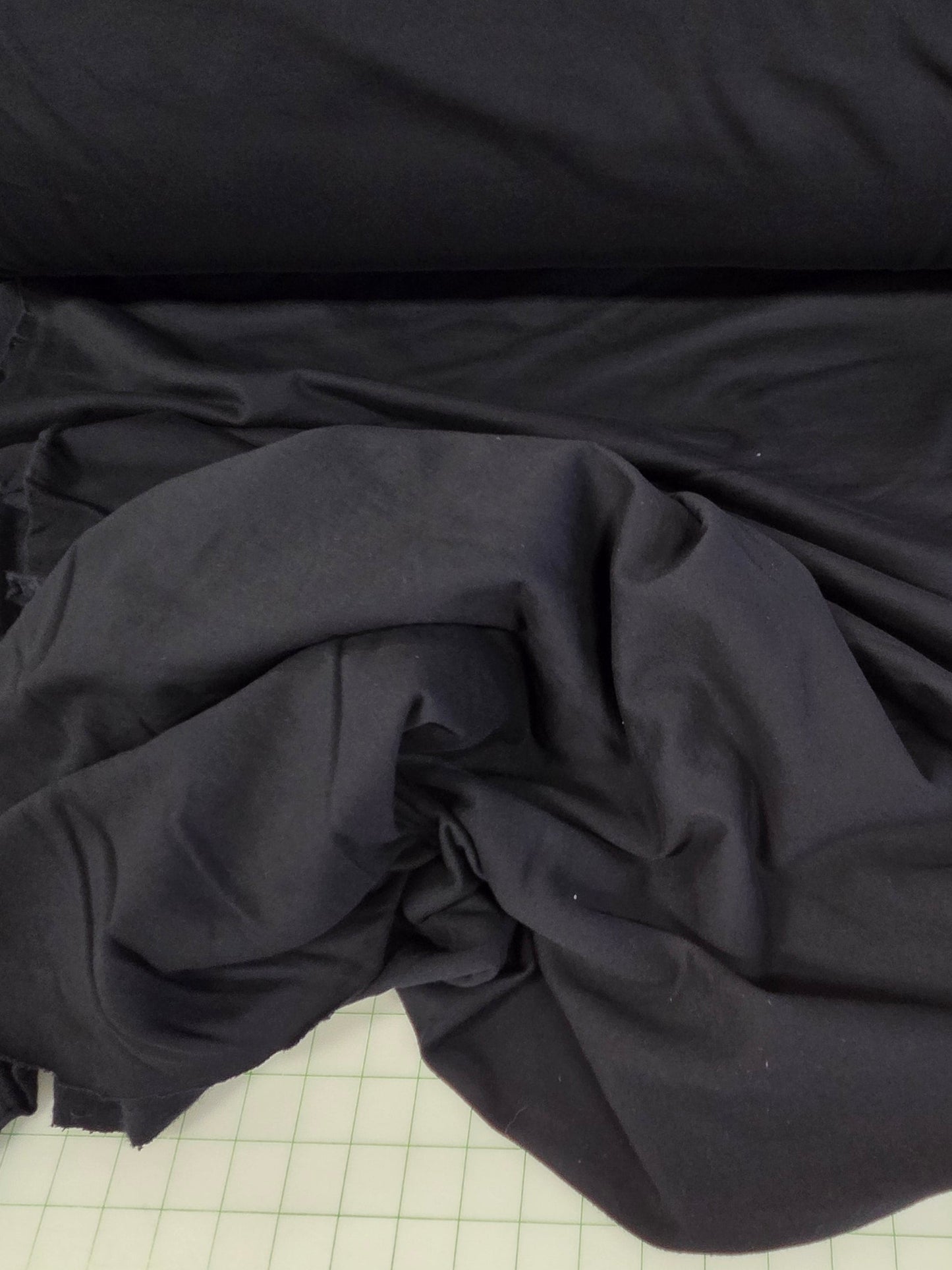 Black fabric on a roll with a measuring chart in the background