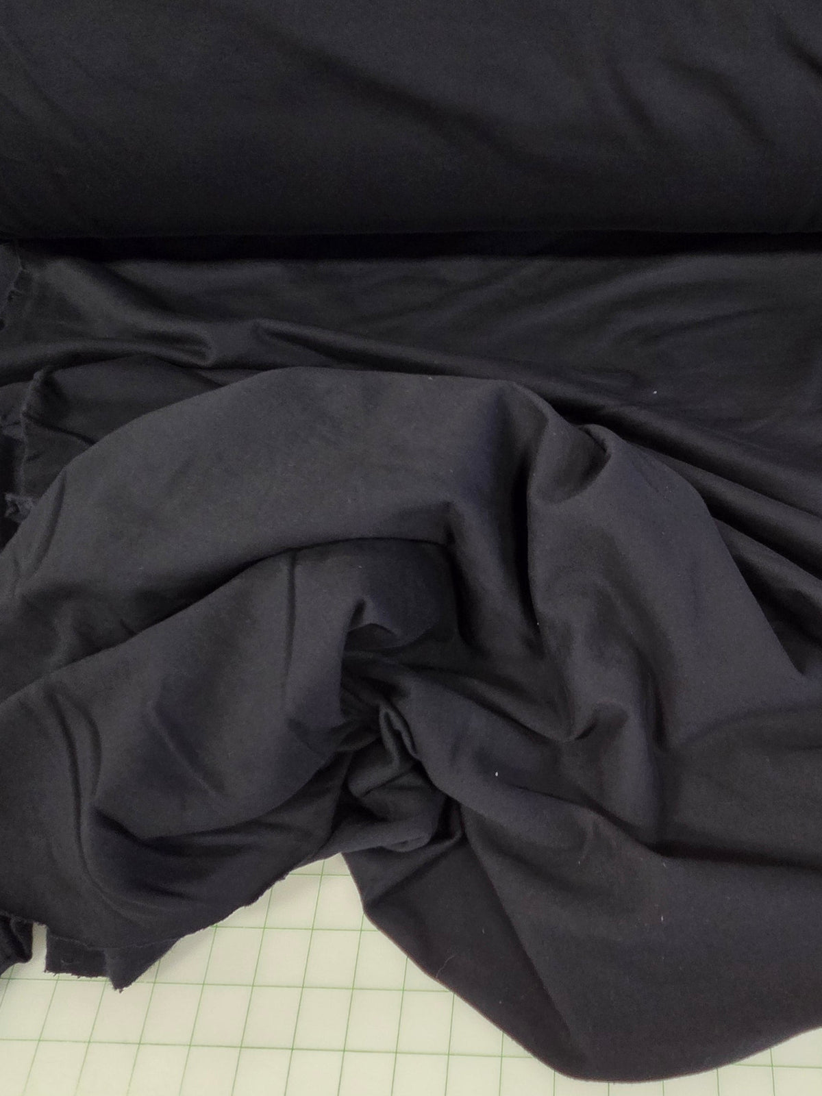 Black fabric on a roll with a measuring chart in the background