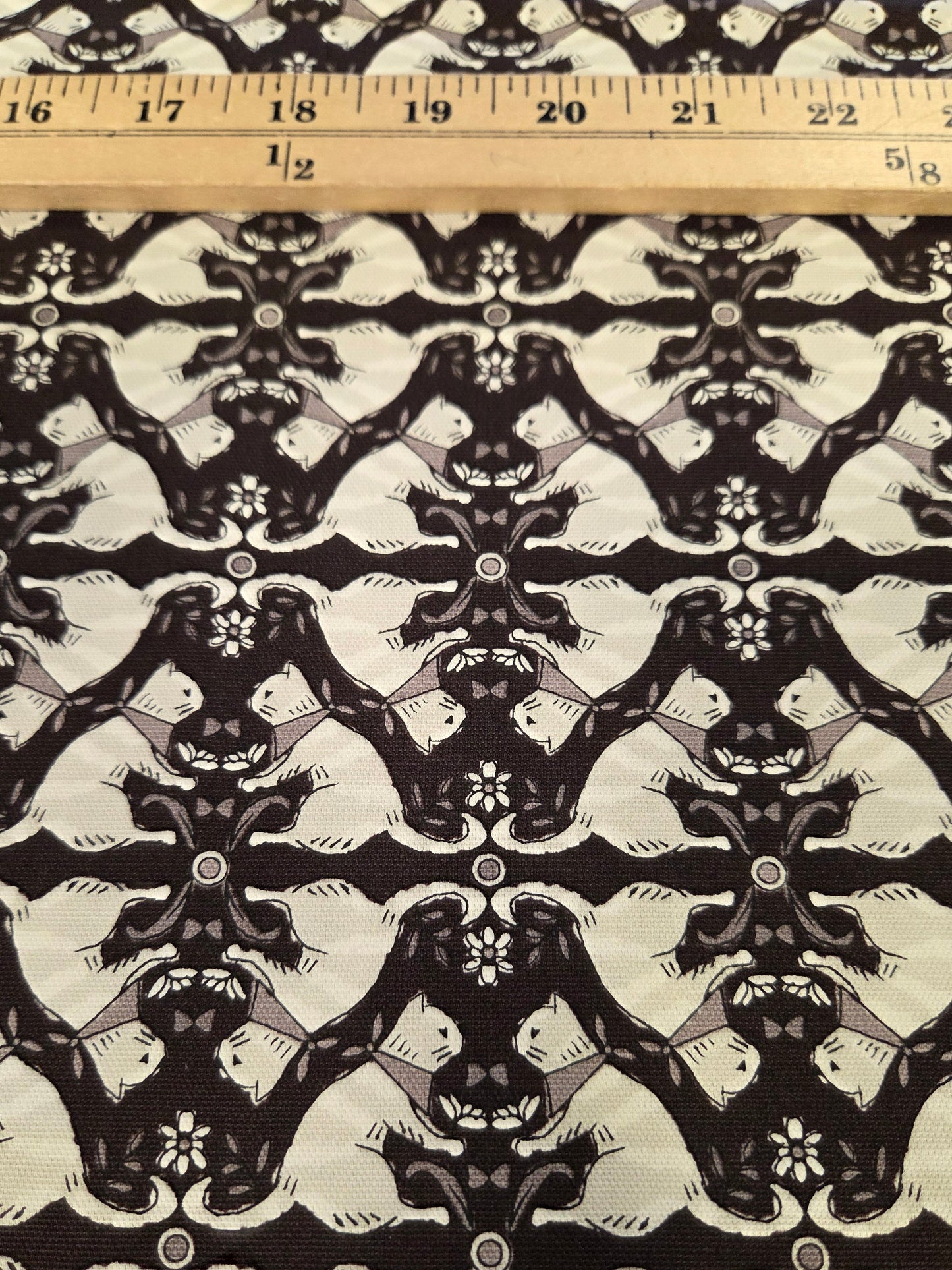 Black and off-white damask patterned fabric with a wooden ruler on the left side for scale.