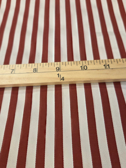 Red and white vertically striped fabric with a wooden 12-inch ruler laid horizontally for scale.