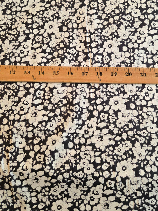 Navy  and white floral patterned fabric with a wooden ruler laid horizontally to show scale. LA Finc Fabrics  Retail yard 