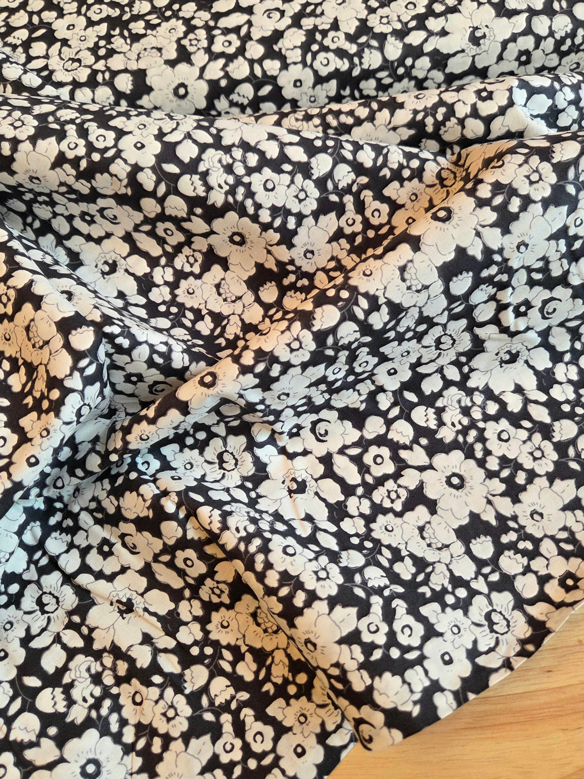 Navy with a dense white and floral print, draped to show its texture and pattern. LA Finch Fabrics Retail Fabric by the yard