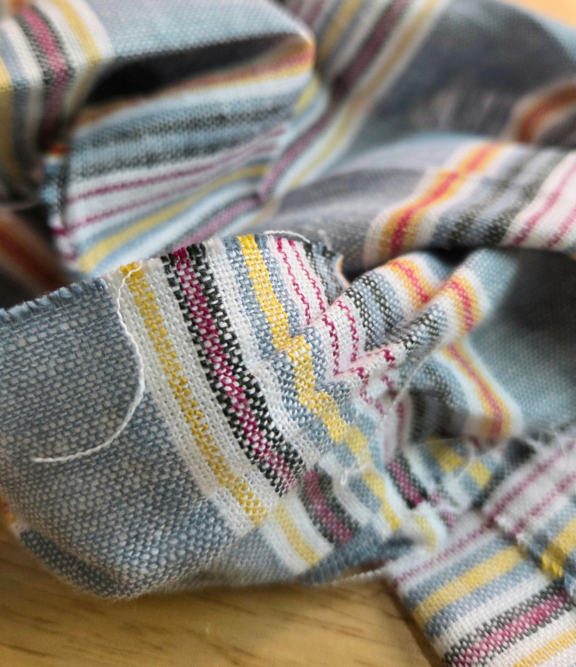 Close-up of a striped fabric with multicolor pattern on a wooden surface