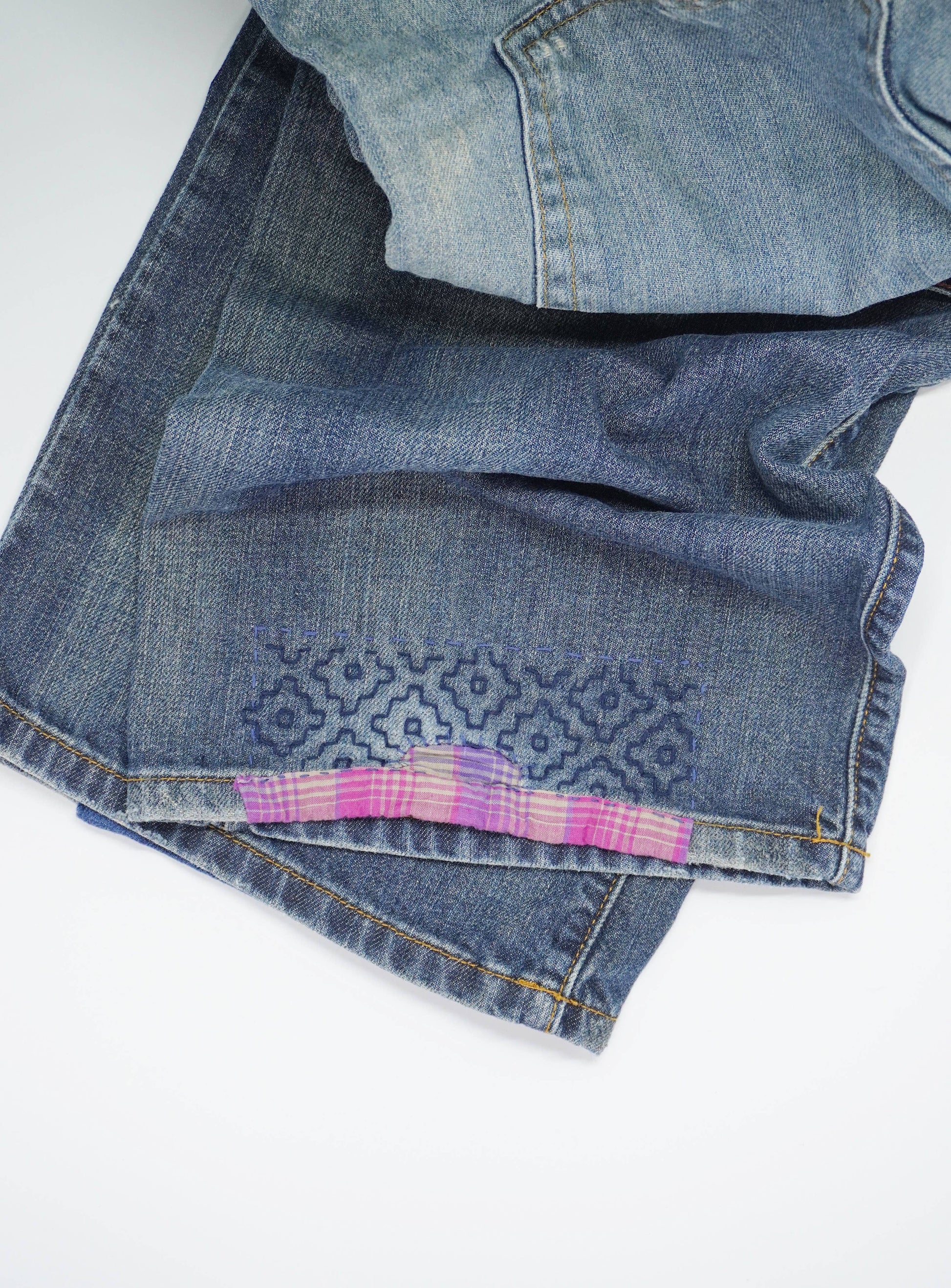 Stack of folded blue jeans on a white background