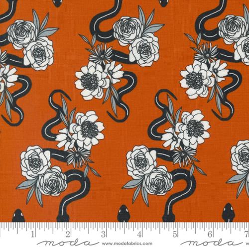 Fabric with snake and flower pattern on an orange background, featuring Moda label.