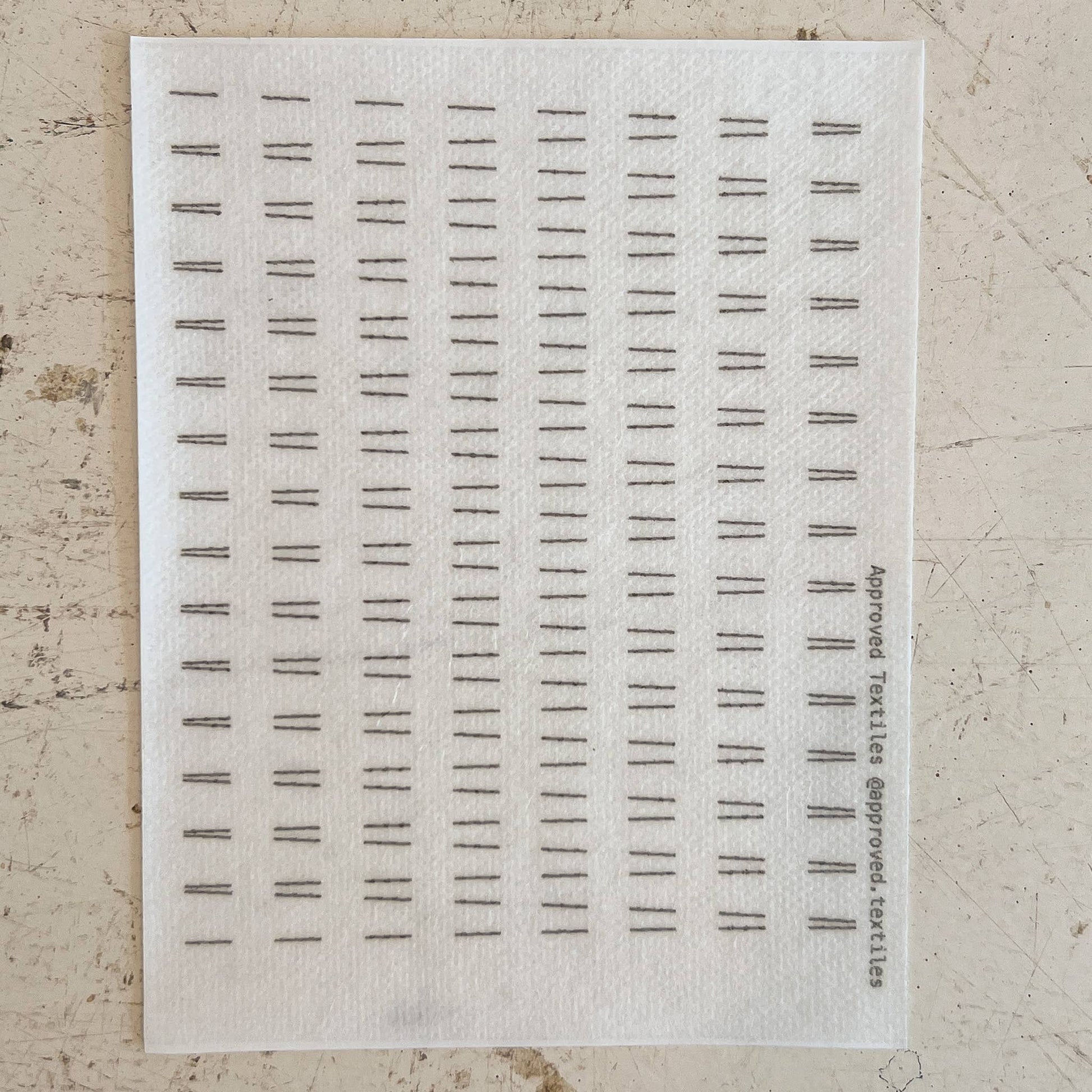 Sheet of black text samples on a textured beige background