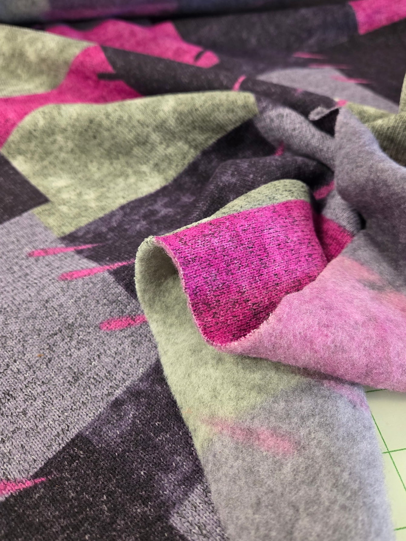 Close-up of patterned fabric with pink, green, and gray colors.