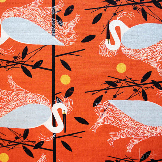 Pattern of white birds on orange background with black leaves and yellow circles. Charley Harper fabric by the half yard, retail fabric LA Finch Fabrics. Southern California
