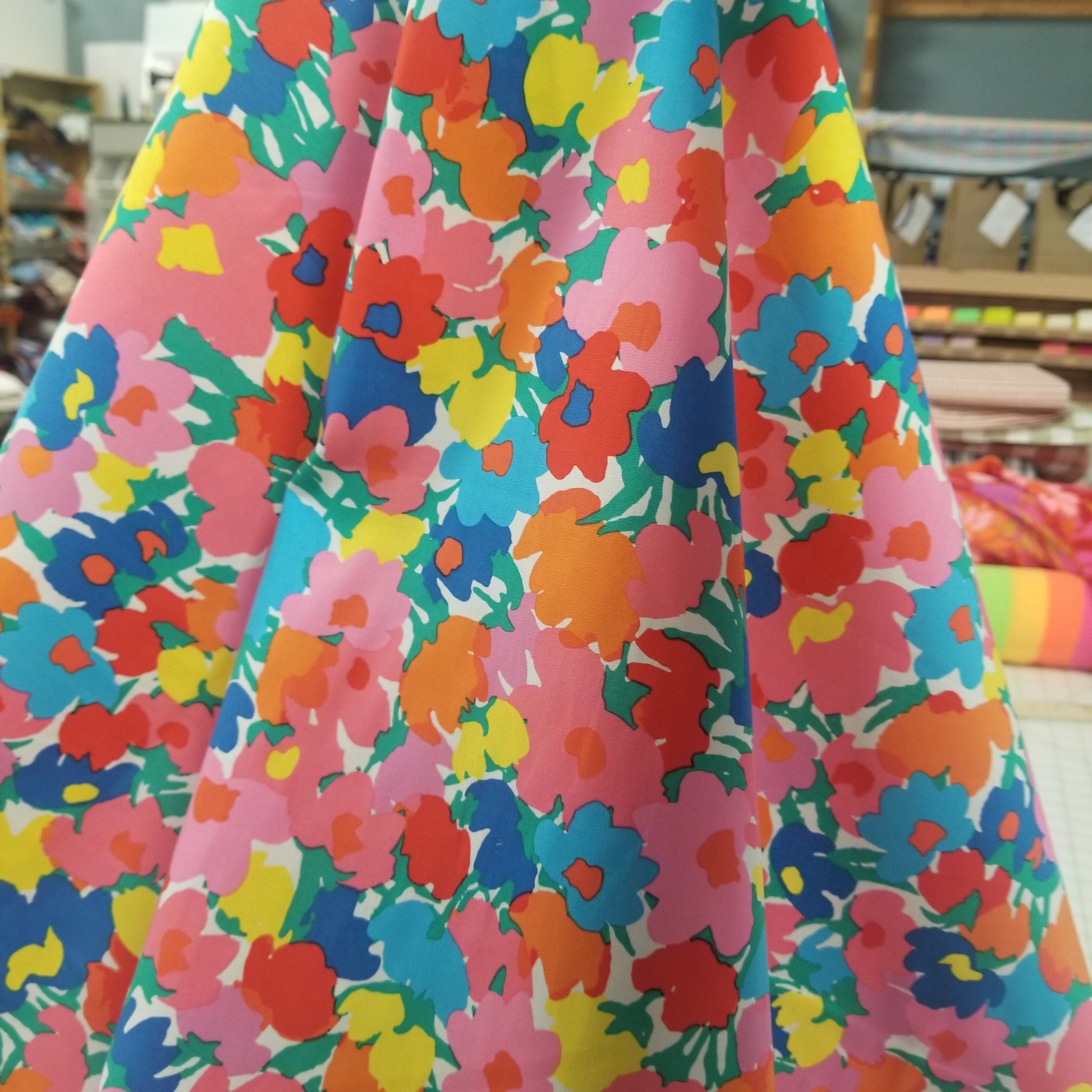Colorful floral fabric with a vibrant pattern on a roll.
