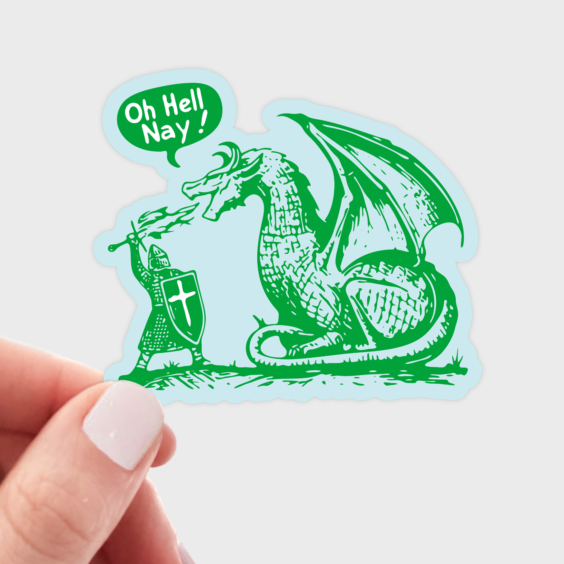 Sticker with a dragon and knight design, held by a hand on a light gray background. Sticker