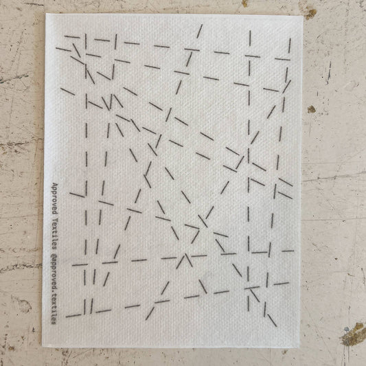 White cloth with black geometric pattern on a textured beige surface