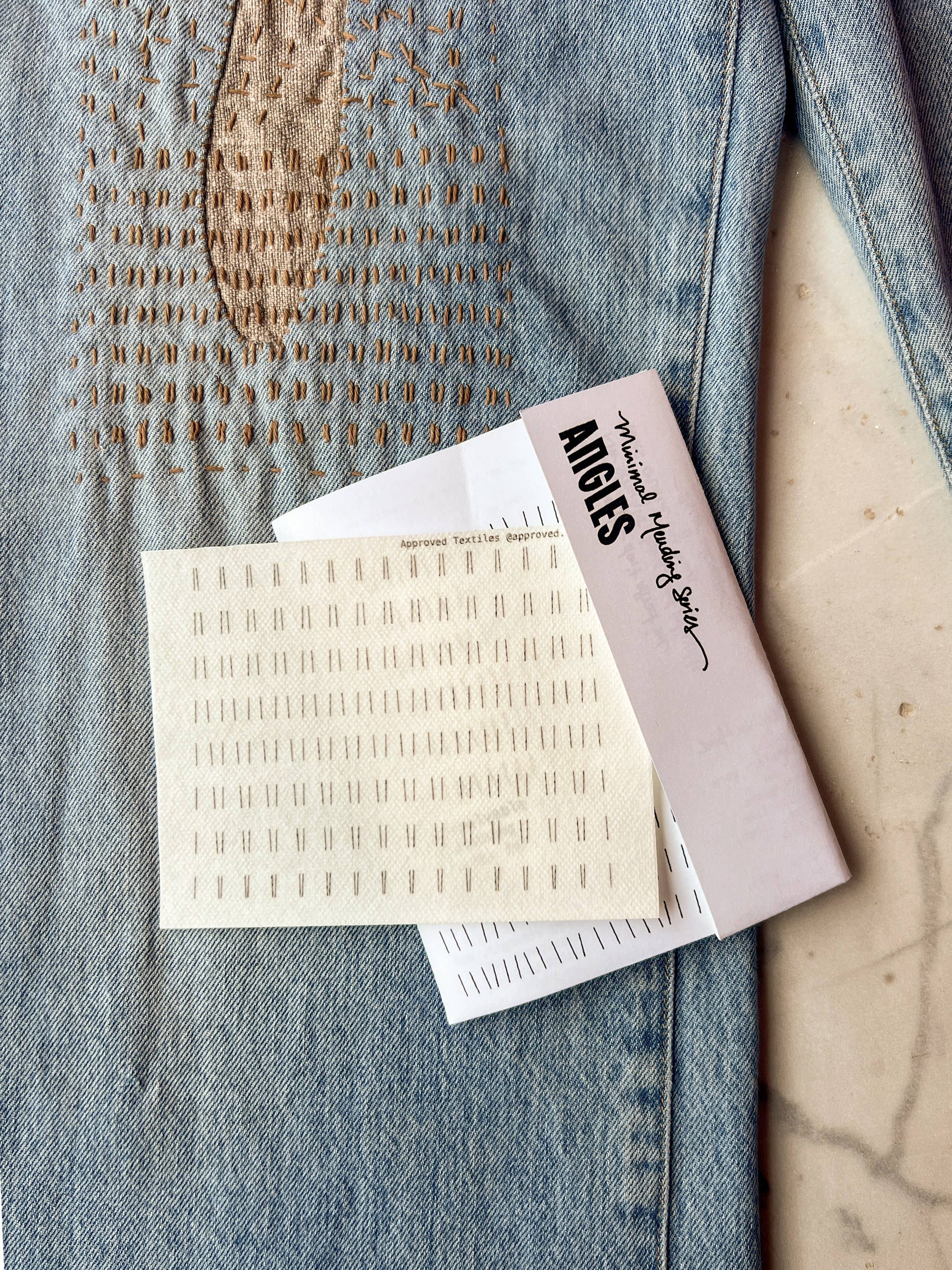 Angies makeup product packaging on a textured surface, visible mending